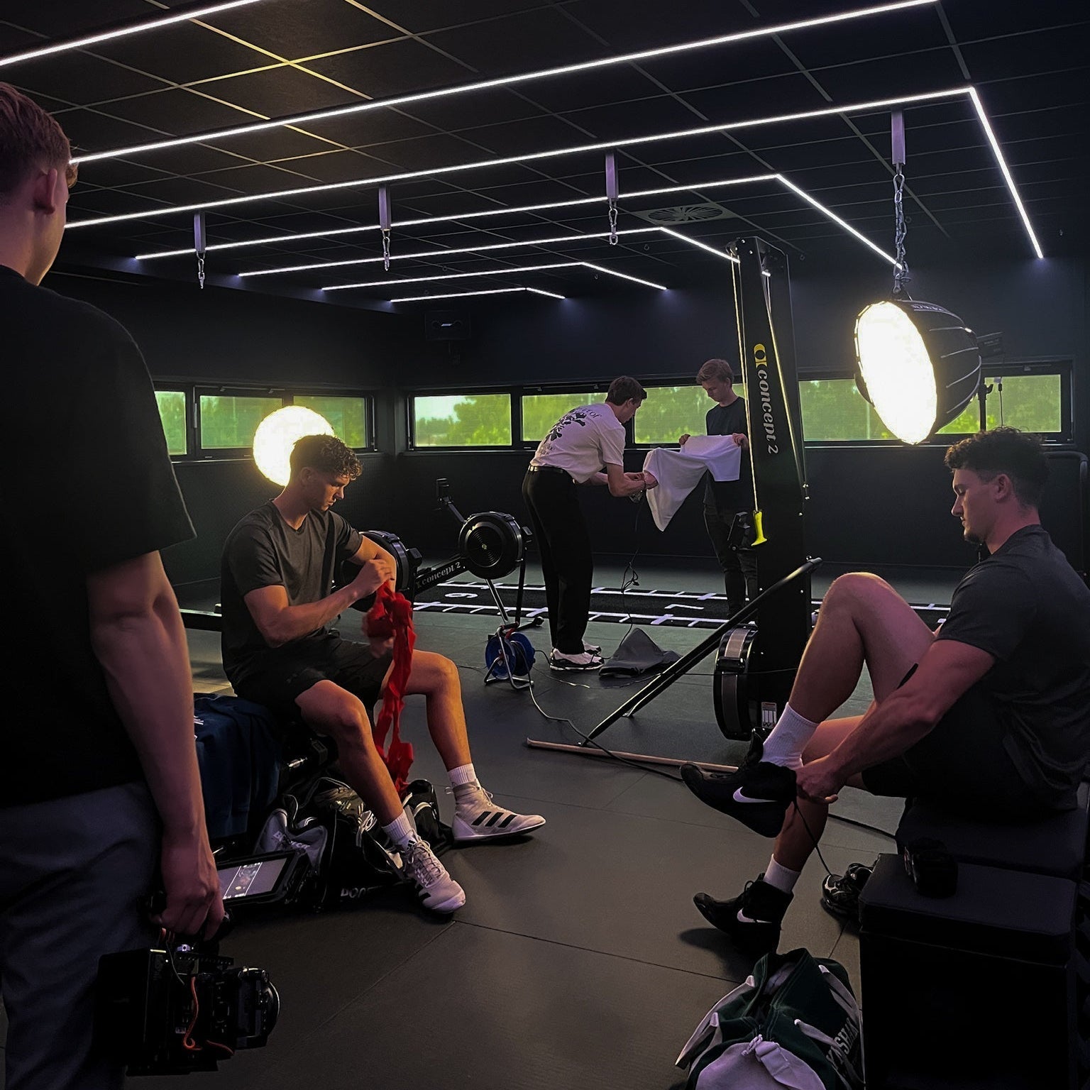 Origin. crew in a dark gym with shoot equipment, lights and preparing for the shoot.