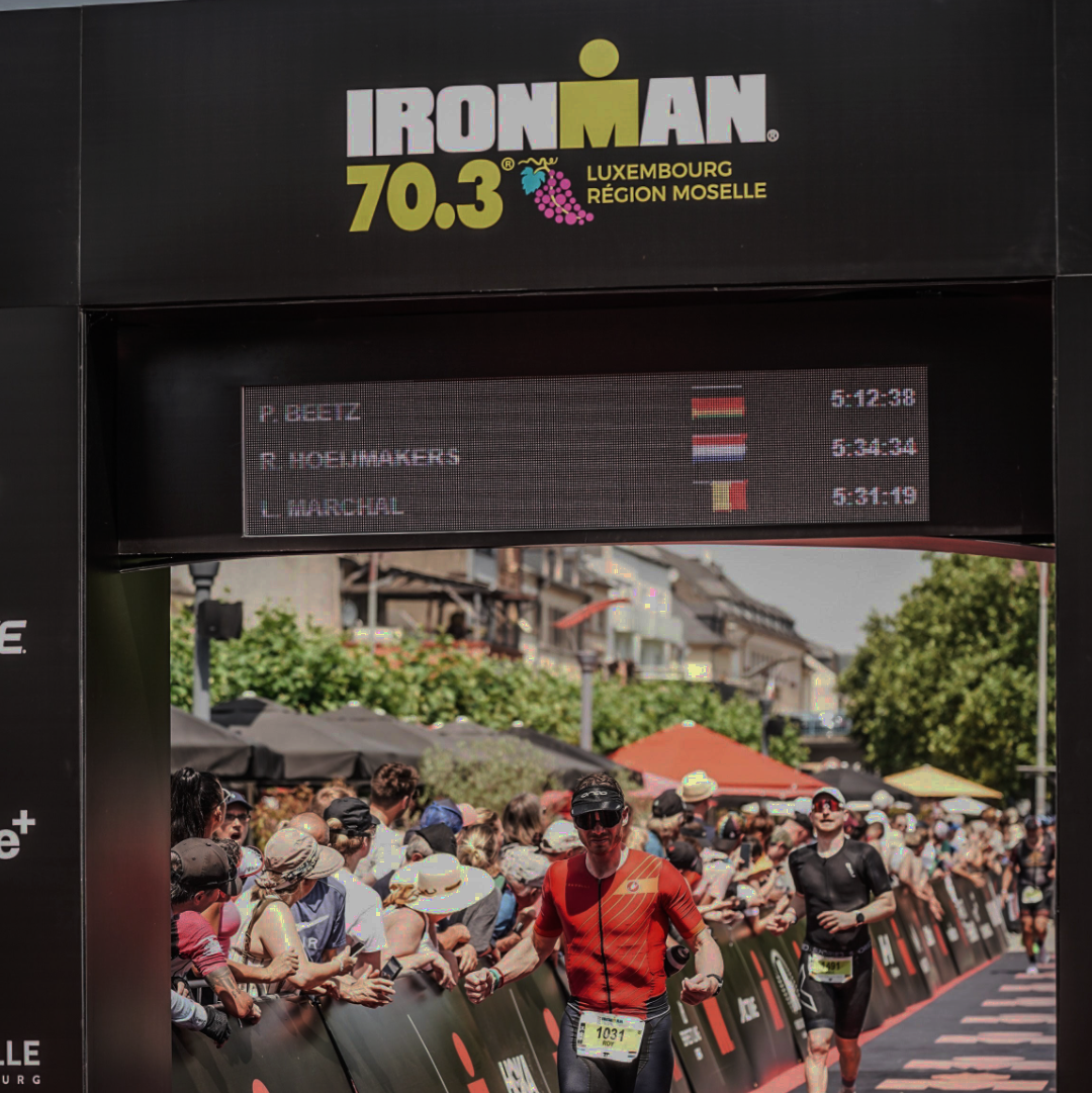 Ironman 70.3 race finish line with Roy crossing the finish line.