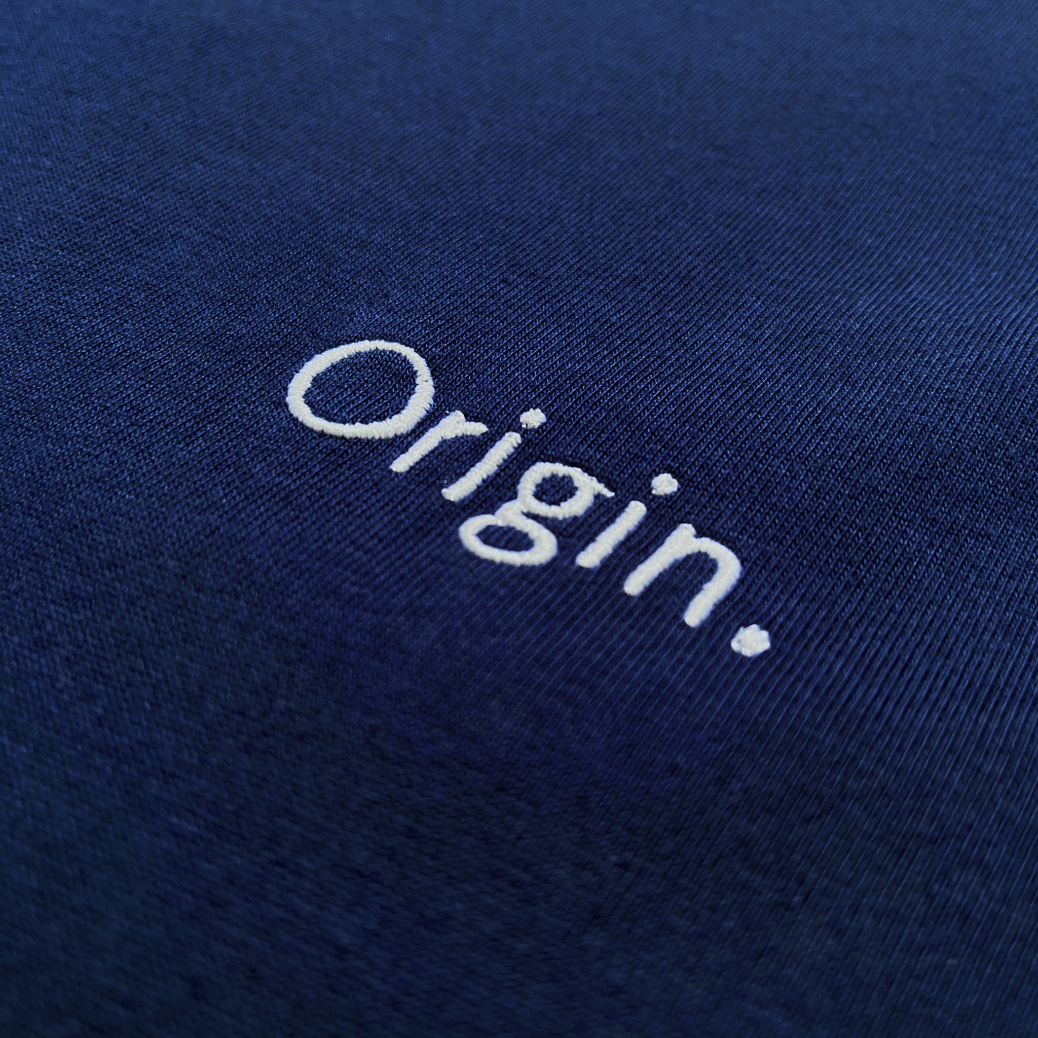 Front detail of Foundation Tee Origin. in indigo blue, featuring embroidery on organic cotton fabric.