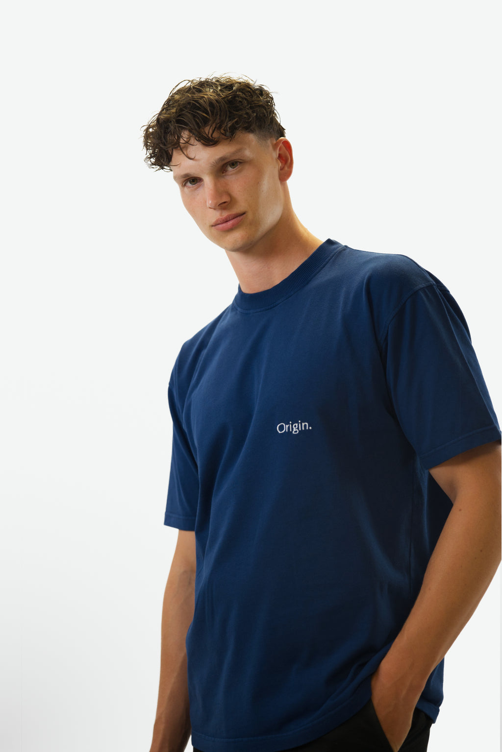 Front view close-up of model wearing the Foundation Tee in indigo blue from Origin. made from organic cotton in a clean studio setting.