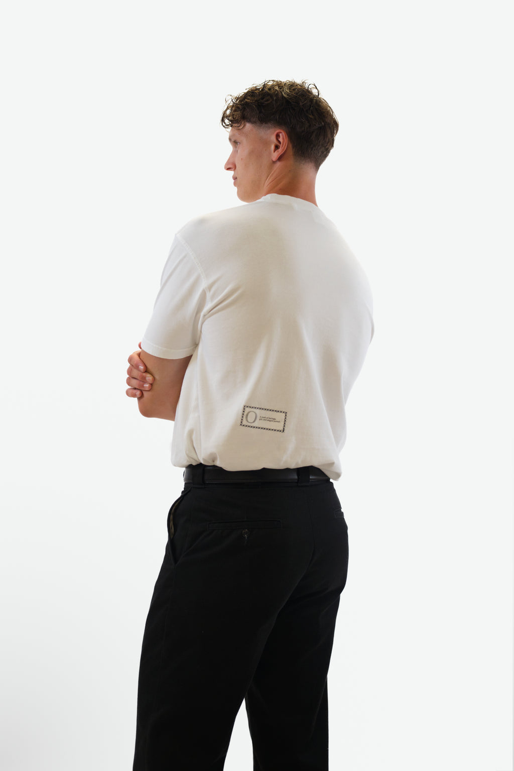 Back view of model wearing the Foundation Tee in white from Origin. made from organic cotton in a clean studio setting.