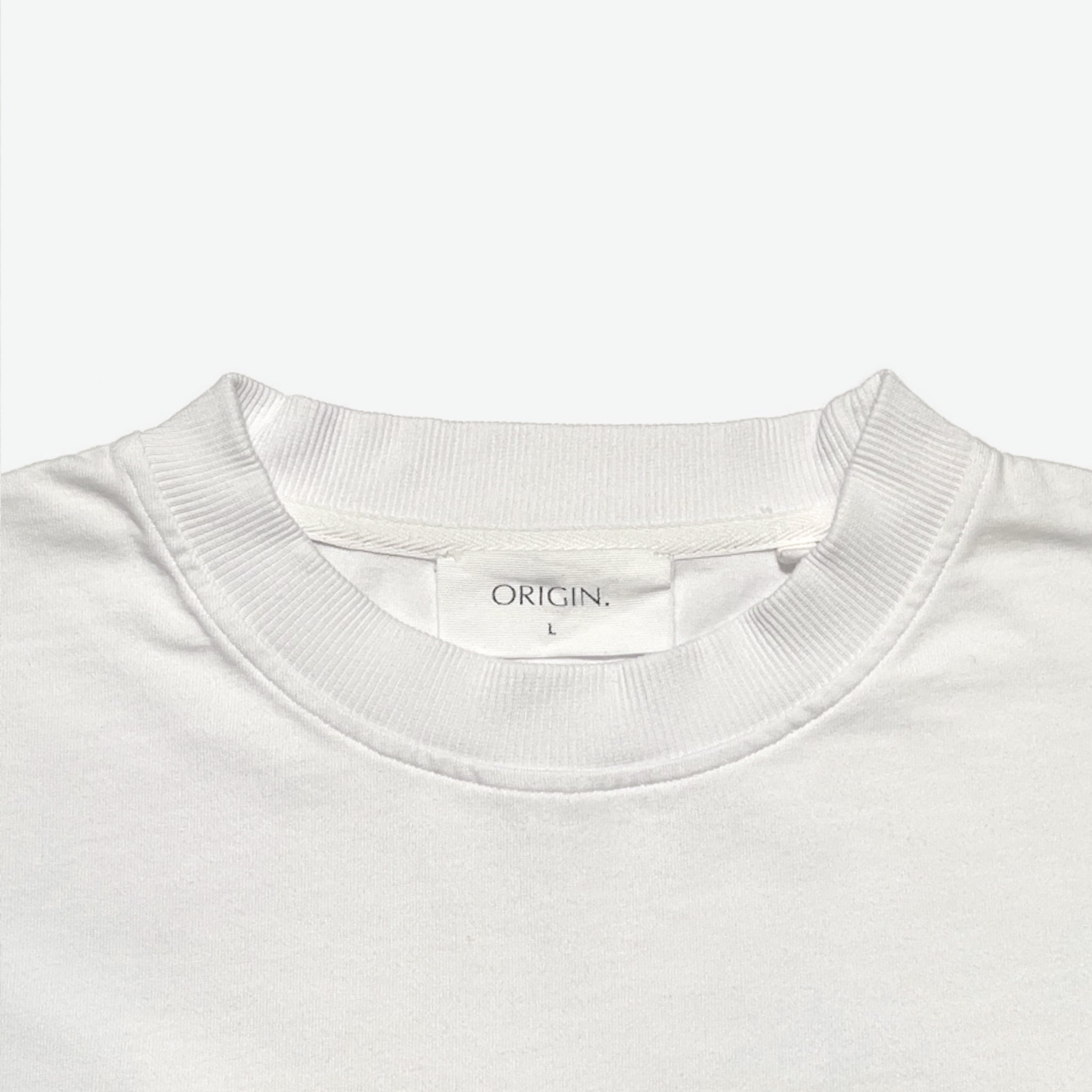 Neck detail Foundation Tee Origin. in white, featuring ribbed collar and organic cotton fabric with branded label.