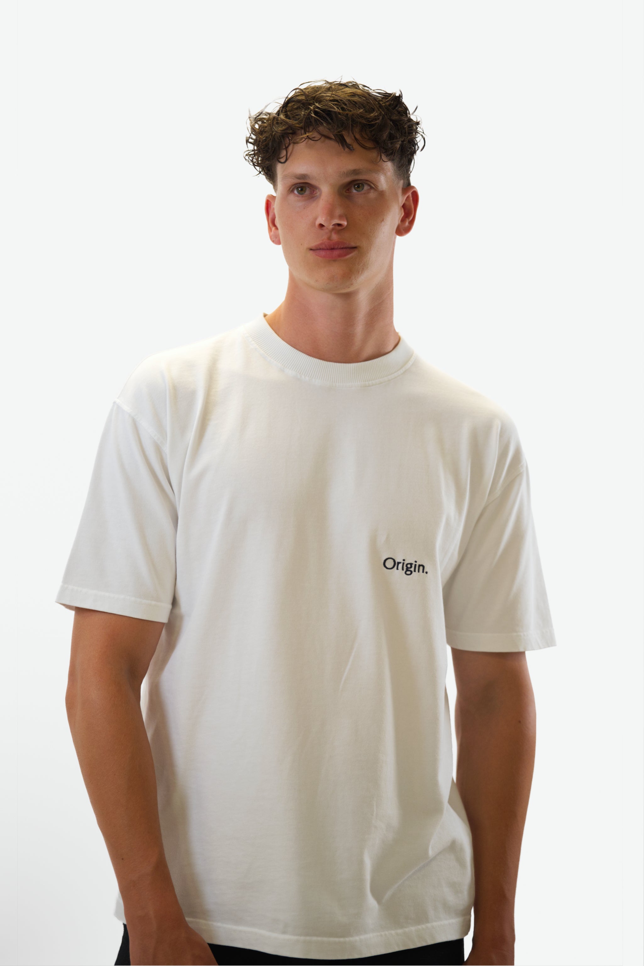 Front view close-up of model wearing the Foundation Tee in white from Origin. made from organic cotton in a clean studio setting.
