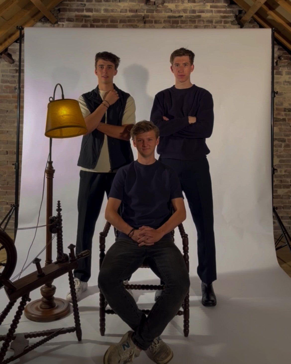 Origin. founders posing in a studio setting with a white backdrop and brick wall.