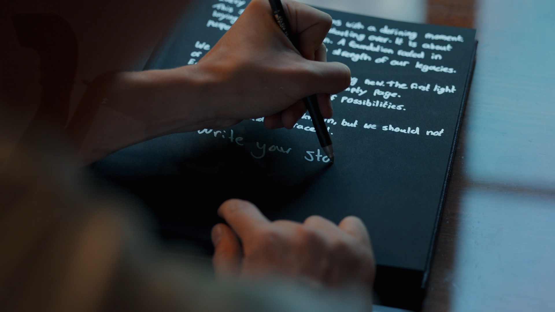 A person writes the Origin. story in a notebook during Chapter One., capturing the brand’s beginnings and vision.