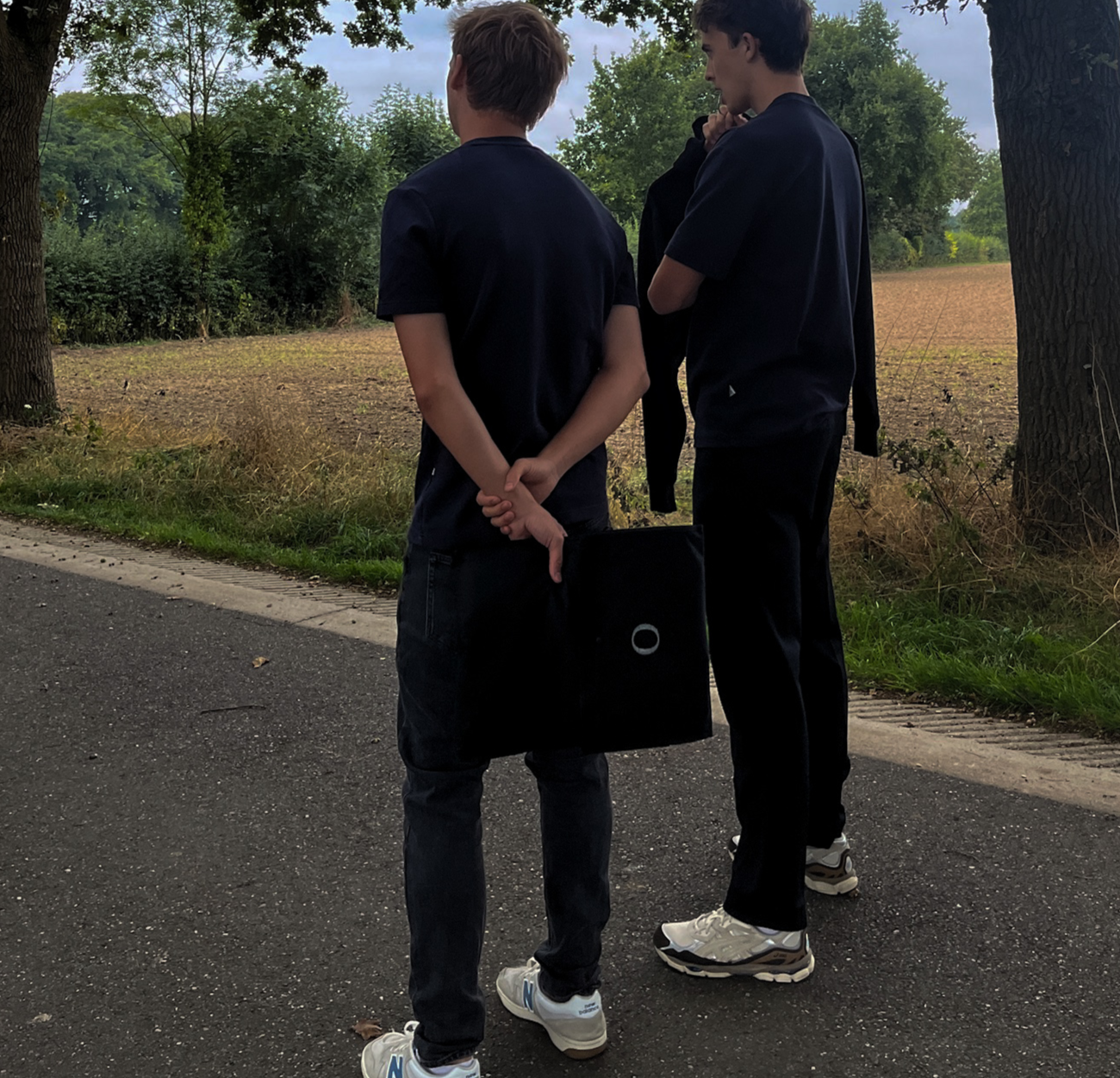 Founders of Origin. watching how product shots where made on a road with trees and grass in the background.