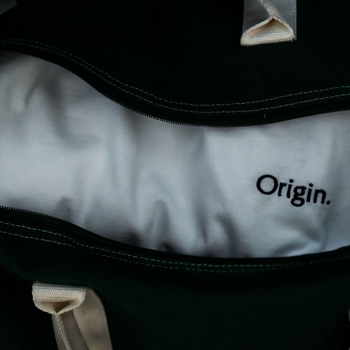 Close-up of a bag with a White Origin. Tee.