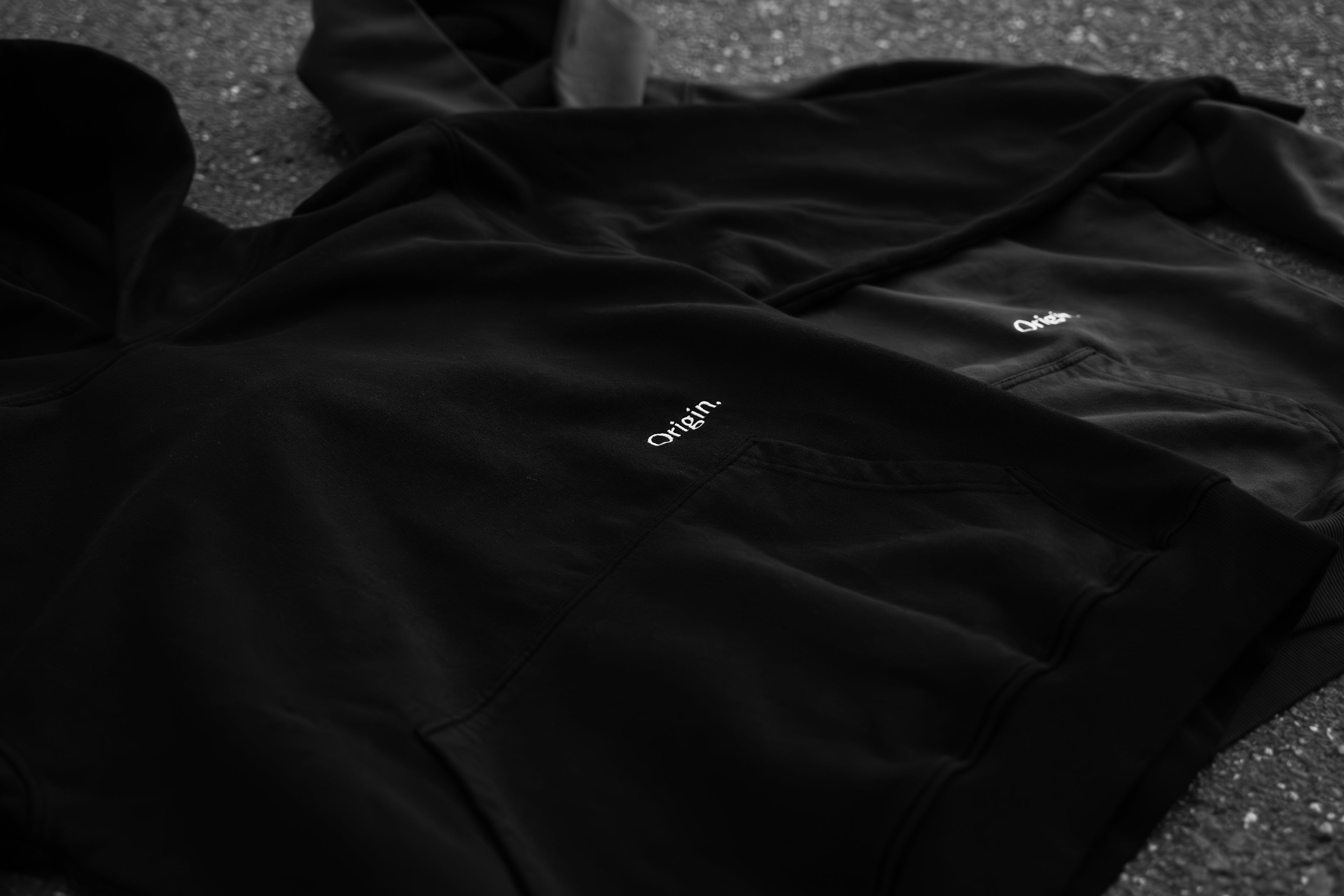 Prelude Hoodie Black and Indigo Blue Origin. lie on the street with a front view.