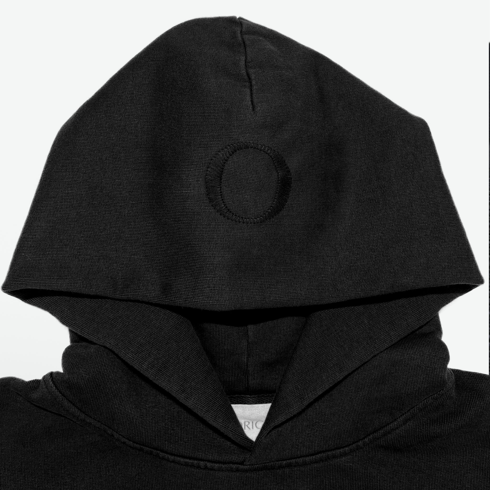 Neck/Hood detail Prelude Hoodie Origin. in black, featuring herringbone neck tape ribbed and organic cotton fabric with branded label.
