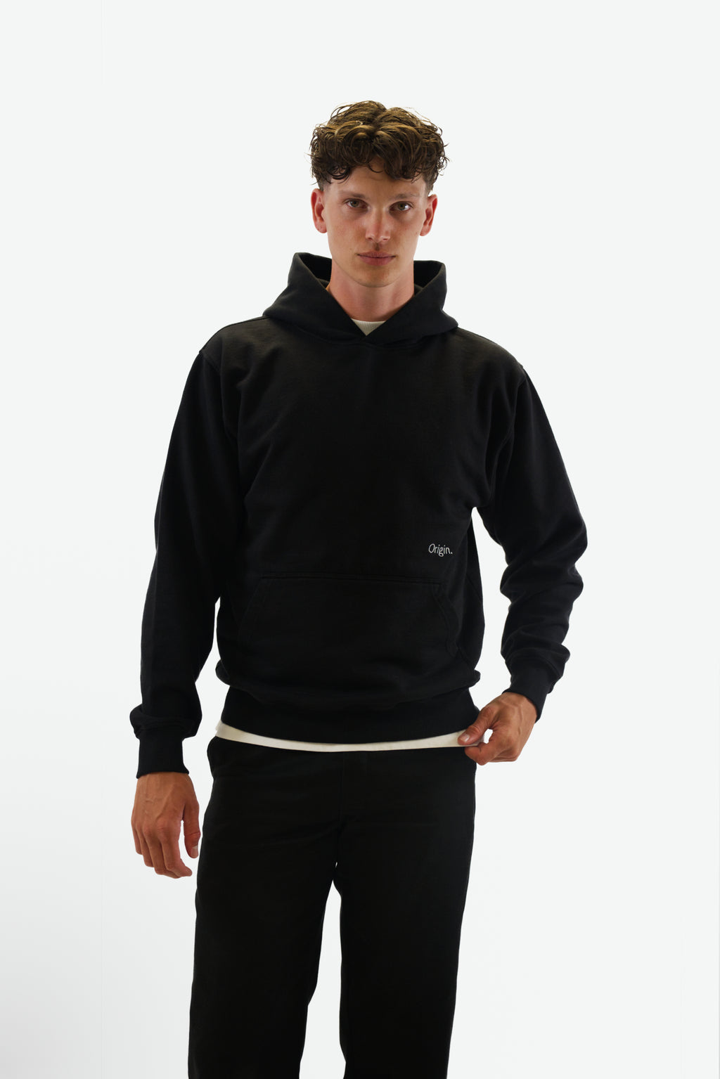 Front view of model wearing the Prelude Hoodie in black from Origin. made from organic cotton in a clean studio setting.