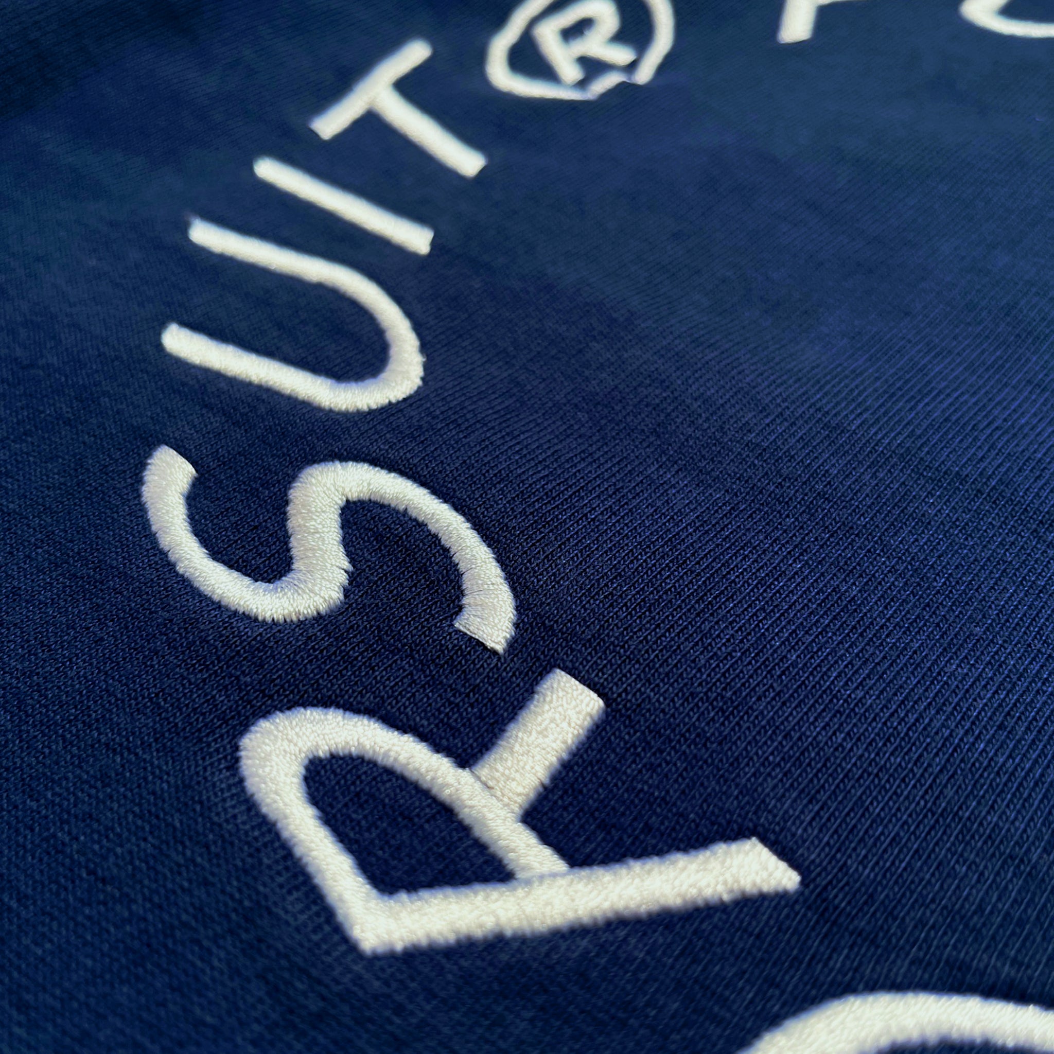 Back detail of Prelude Hoodie Origin. in Indigo Blue, featuring embroidery on organic cotton fabric.