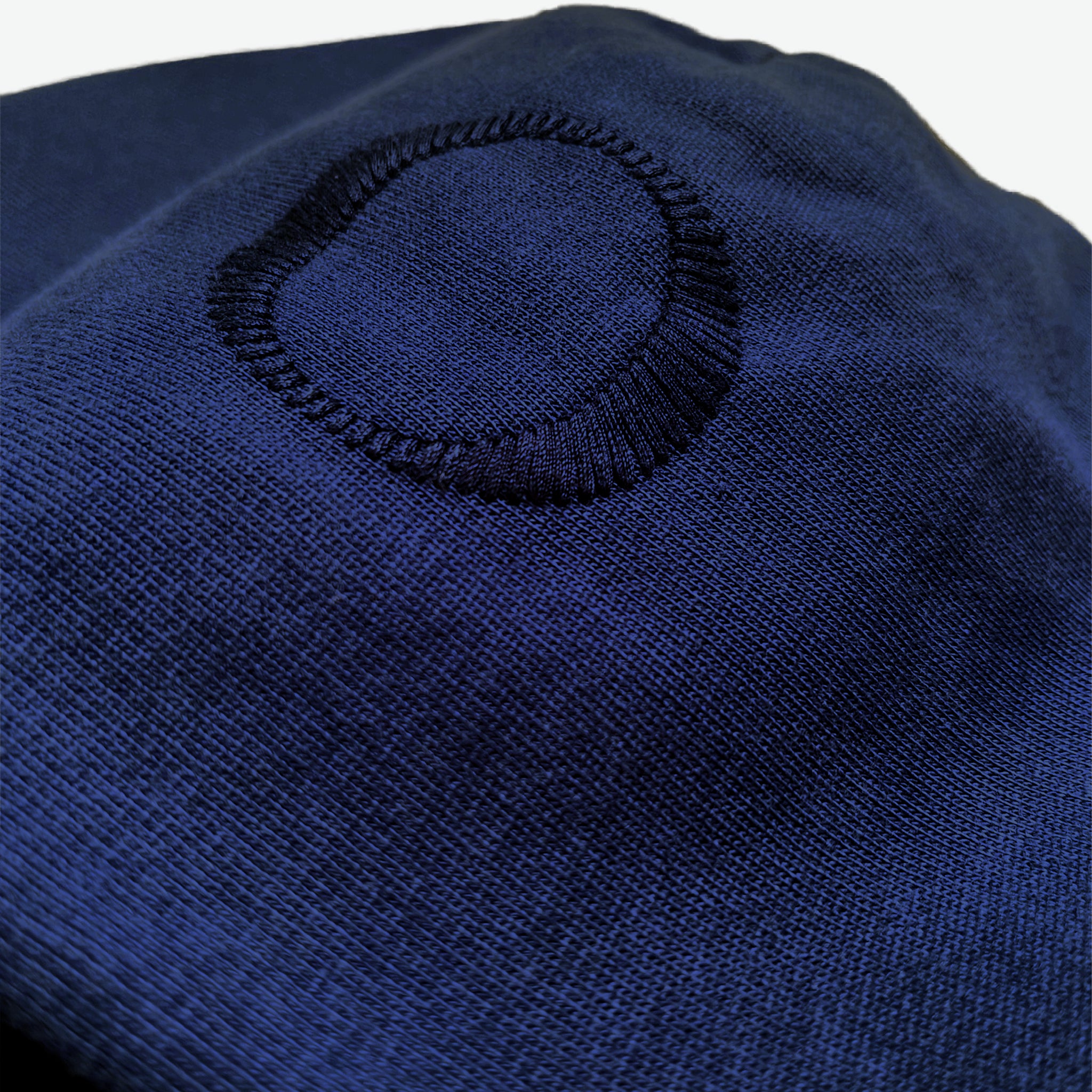 Hood detail of the Prelude Hoodie Origin. in Indigo Blue, featuring hood embroidery from Origin. Slash Logo on organic cotton fabric.