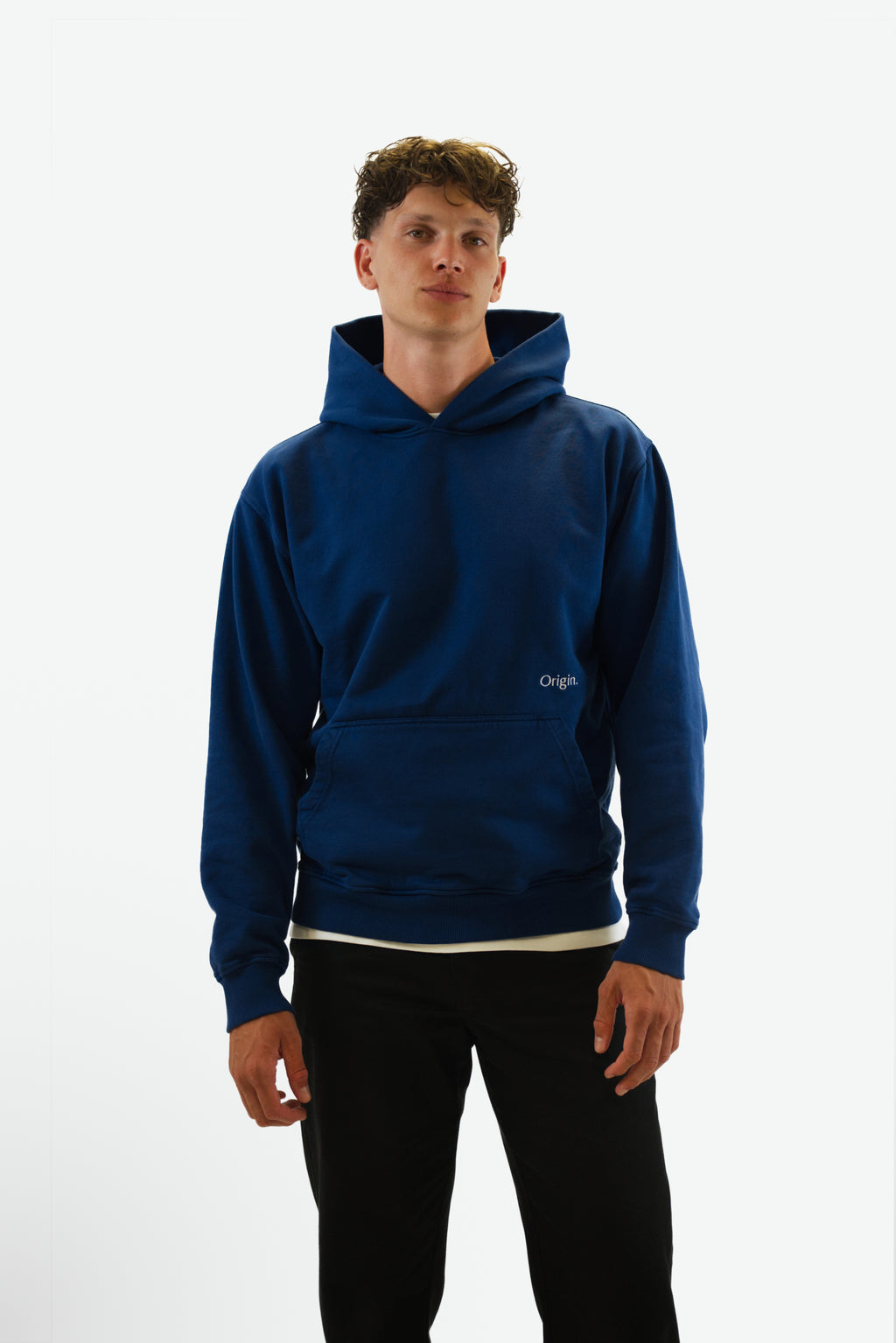Front view of model wearing the Prelude Hoodie in indigo blue from Origin. made from organic cotton in a clean studio setting.