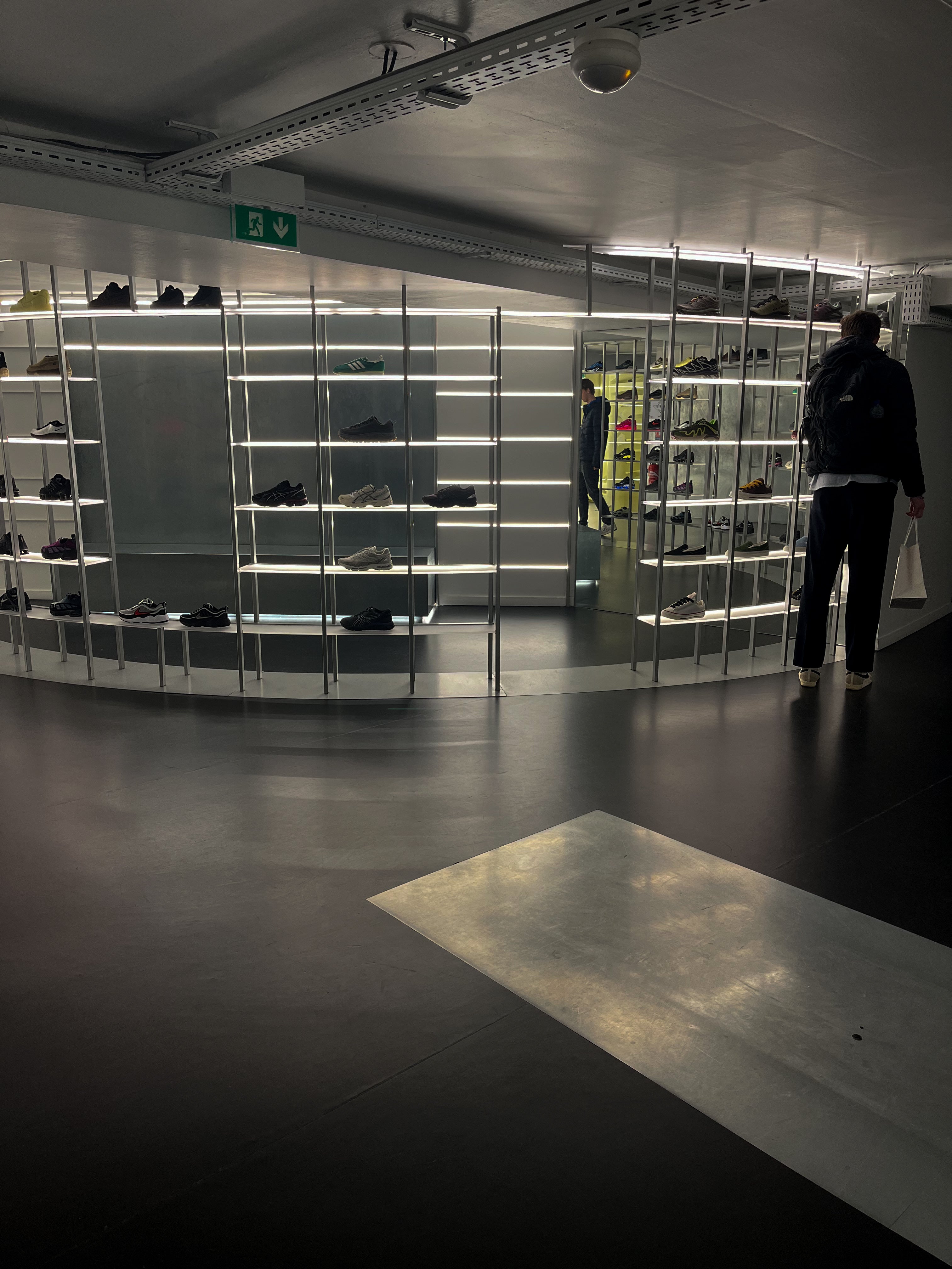 Shoe display area with shelves in a store in Paris and founder clothing brand Origin. standing in front of the shelves.