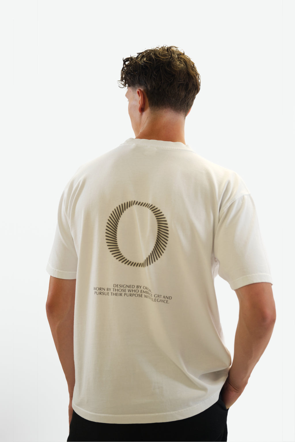 Back view close-up of model wearing The Slash Tee in white from Origin. made from organic cotton in a clean studio setting.