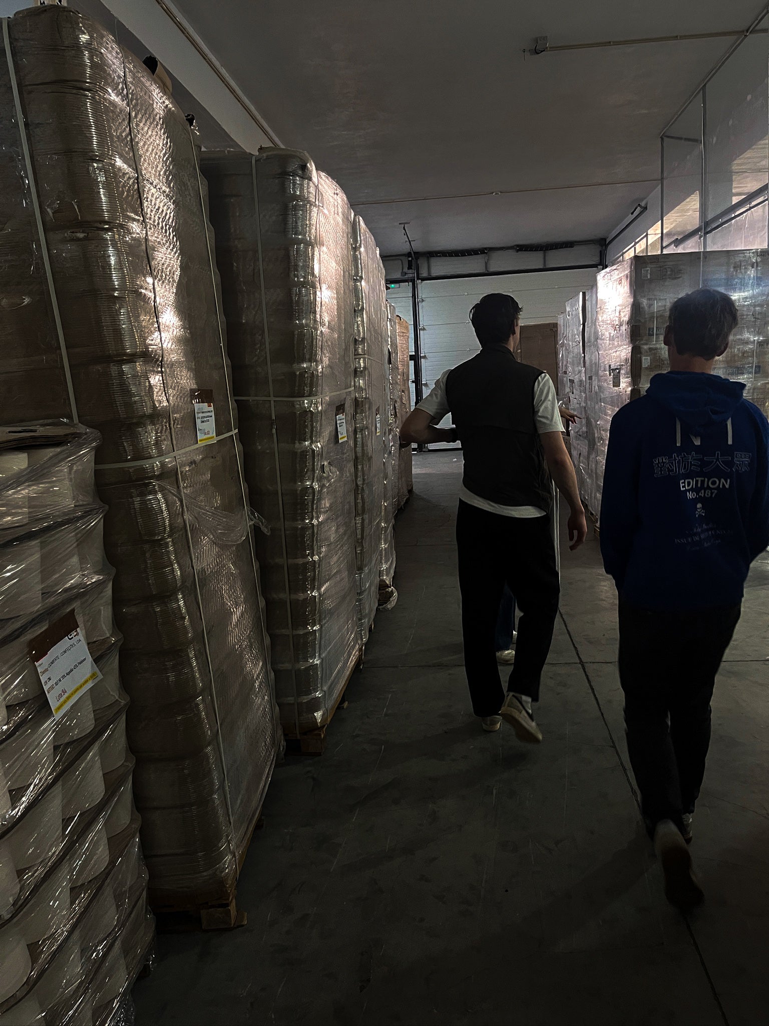 Founders Origin. walking through a warehouse of a Portuguese clothing factory that makes the organic cotton clohting for Origin.